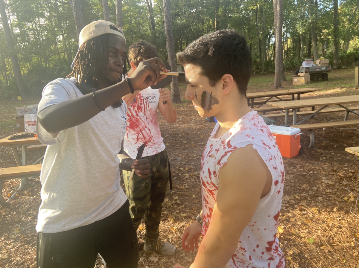 Two scare actors work on applying fake blood to one another before being sent into the trails. 